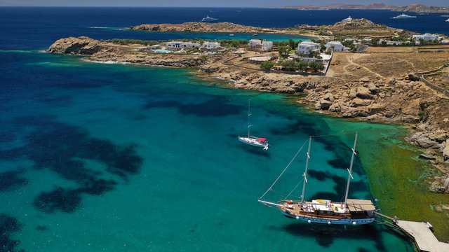 Aerial drone photo of famous organised with sun beds and umbrellas beach of  Paradise with emerald clear sandy sea shore, Mykonos island, Cyclades, Greece  
