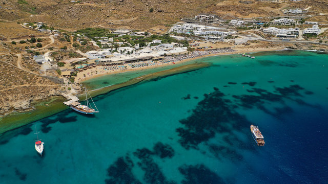 Aerial drone photo of famous organised with sun beds and umbrellas beach of  Paradise with emerald clear sandy sea shore, Mykonos island, Cyclades, Greece  