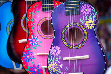 A group of colorful painted mexican made guitars