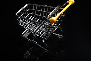 Close-up of shopping carts on black background.Trolley, Sale concept.Empty grocery shopping cart. Isolated over black background.