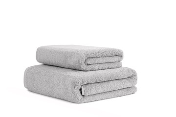 Gray terry towels folded and stacked isolated. Terry towels against white backdrop. Folded soft bath towels. Stack of cotton towels on a white background