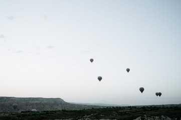 Hot air balloons landing in a mountain Cappadocia Goreme National Park Turkey.