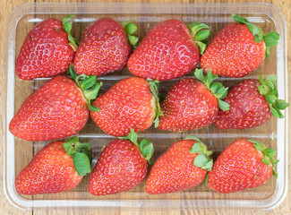 Box of fresh strawberry. Wooden background.