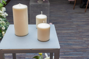 Fototapeta na wymiar three decorative candles on an iron table
