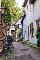 Fototapeta na wymiar Bicycles and trees in cozy backyard in Europe. Summer patio with bikes. Bicycles in front of old house. Traditional exterior of houses in Amsterdam. European architecture concept. Old town.