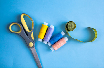Set of tailoring accessories on light background, top view