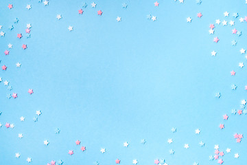 Little stars confetti on blue background. Holyday concept. Copy space for your text.