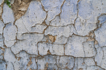 Old cracked parget (plaster) on a painted blue medieval wall of a house in Lefkara heritage village on Cyprus