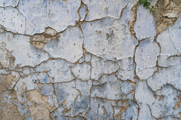 Old cracked parget (plaster) on a painted blue medieval wall of a house in Lefkara heritage village on Cyprus