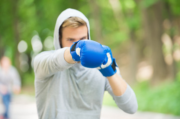 Nice punch. Boxing training endurance. Man athlete concentrated face with sport gloves practicing...