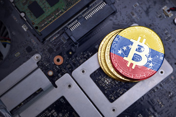 golden bitcoins with flag of venezuela on a computer electronic circuit board. bitcoin mining...