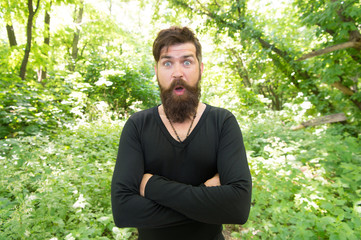 Naklejka na ściany i meble Handsome man with beard and mustache in nature. Brutality of jungles concept. Summer heat season. Wild nature. Man bearded hipster bright foliage background. Guy relax in forest. Exploring nature
