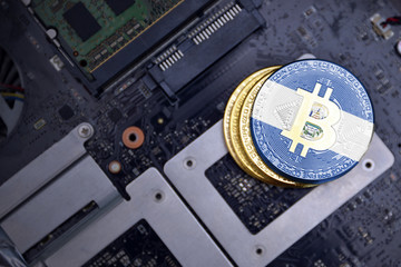 golden bitcoins with flag of el salvador on a computer electronic circuit board. bitcoin mining...