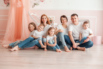 Happy two families sitting on the floor in living room