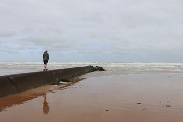 Boy walks out to the ocean at Omaha Beach