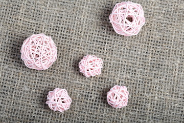 Pink rattan balls. Laid out on a rough linen fabric.