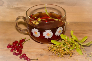 cup of linden tea and dried linden flowers on a wooden background