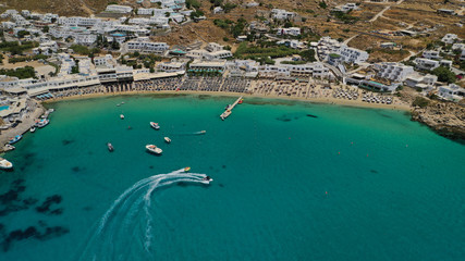 Fototapeta na wymiar Aerial panoramic photo of famous turquoise clear sea celebrity sandy beach and bay of Psarou with yachts and sail boats in iconic island of Mykonos, Cyclades, Greece