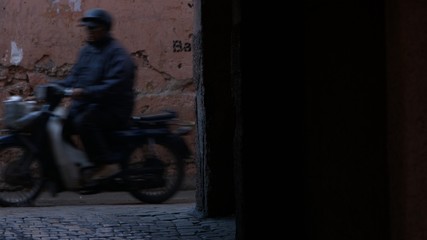 Fototapeta na wymiar Marrakesh, Figure walking through a tight in Moroccan alley way