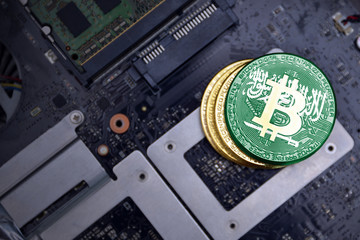 golden bitcoins with flag of saudi arabia on a computer electronic circuit board. bitcoin mining...