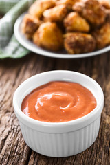 Homemade fry sauce made of ketchup and mayonnaise with fried breaded cauliflower florets in the...