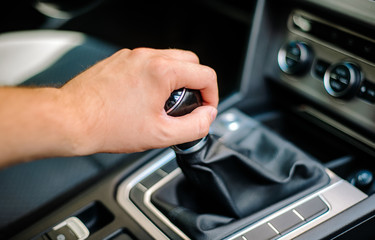 Hand of the driver on the gear knob in the car. Transport concept and manual transmission. Driving, transmission failure.