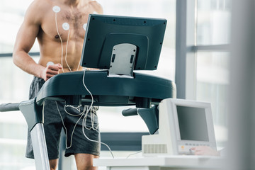 selective focus of sportsman with electrodes running on treadmill during endurance test in gym © LIGHTFIELD STUDIOS