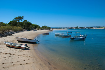 Fototapeta na wymiar Beach and boats in the water at Tavira Island known as Ilha de Tavira in the Algarve in Portugal