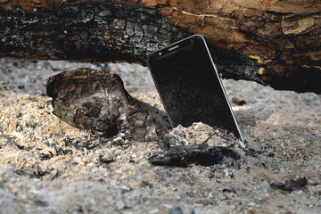 phone in the ashes of a firewood firewood dust side sun made charred log