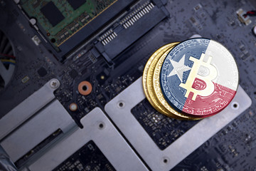golden bitcoins with flag of texas state on a computer electronic circuit board. bitcoin mining concept.