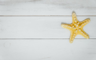 Fototapeta na wymiar Starfish from the sea on a wooden white background. The concept of holidays and the import of souvenirs from the sea. Returning home from vacation. Sea shells isolated.