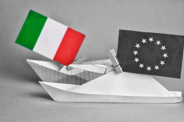 paper ship with Flags of European Union and Italy - abstract bureaucratic struggle