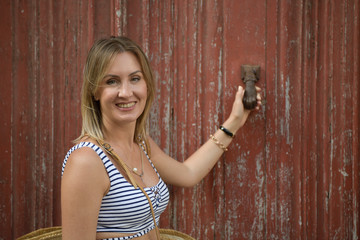 Side view portrait of a woman smiling and looking at camera on red background