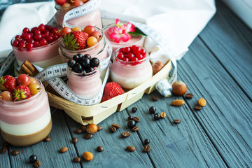 Concept diet - healthy food yogurt with summer berry and fitness dessert three layers of milk jelly pudding, coffee, vanilla and berry