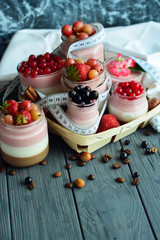 Concept diet - healthy food yogurt with summer berry and fitness dessert three layers of milk jelly pudding, coffee, vanilla and berry
