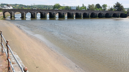 Fototapeta na wymiar The medieval bridge over the river Taw at Barnstaple, England. Known as the Barnstaple Long Bridge, it is founded on sixteen arches and is officially classified as an ancient monument 