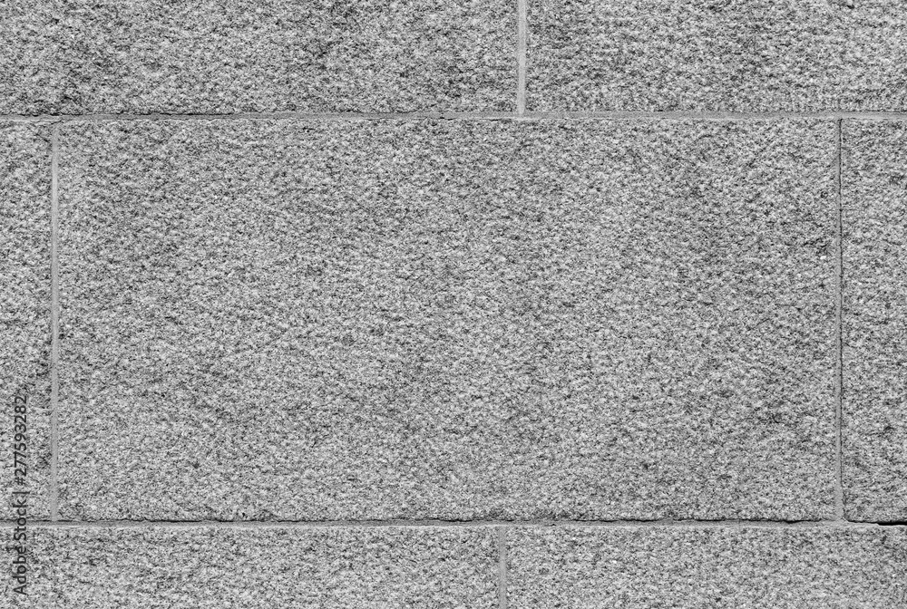 Poster close-up of part of a bumpy granite block stone wall in black and white. high resolution full frame 