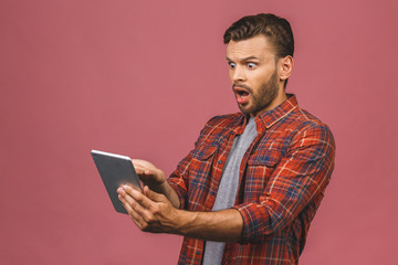 Amazed happy guy using digital tablet looking shocked about social media news, astonished man...