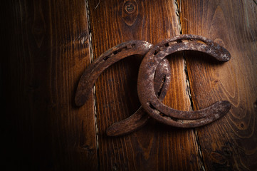 Equesrtian background. Lucky old  horseshoes laying at wooden background.