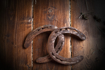 Equesrtian background. Lucky old  horseshoes laying at wooden background.