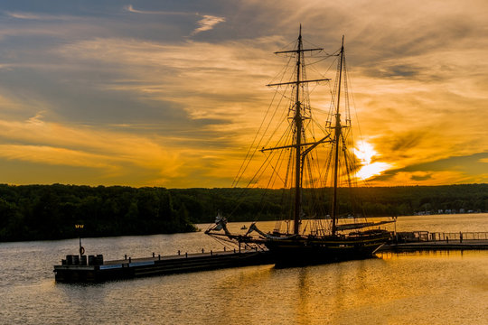 Two-masted brig moored at sunset at the pier