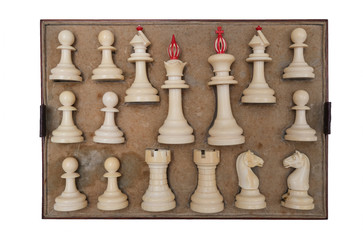 White chess pieces made of bone in a wooden box on a white background.