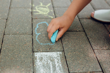 Children's hand draws with chalk on the pavement.