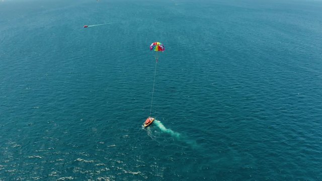 Tourists on a parachute over the sea, aerial view. Tourists parasailing on the Boracay, Philippines.