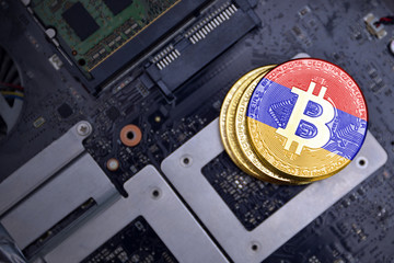 golden bitcoins with flag of armenia on a computer electronic circuit board. bitcoin mining concept.