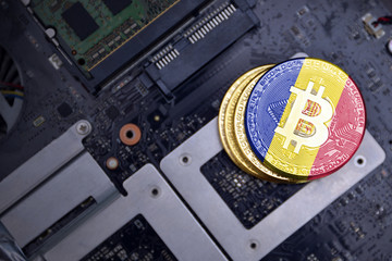 golden bitcoins with flag of andorra on a computer electronic circuit board. bitcoin mining concept.