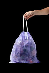mens hand with full trash bag isolated on black background. garbage collection. waste treatment. environmental protection.
