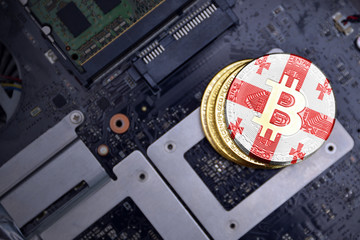 golden bitcoins with flag of georgia on a computer electronic circuit board. bitcoin mining concept.