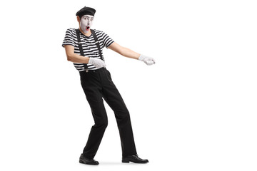 Mime pretending to pull a rope