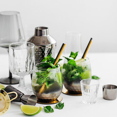 Cocktail with lime, mint and ice and  bar accessories on. Summer drinks.